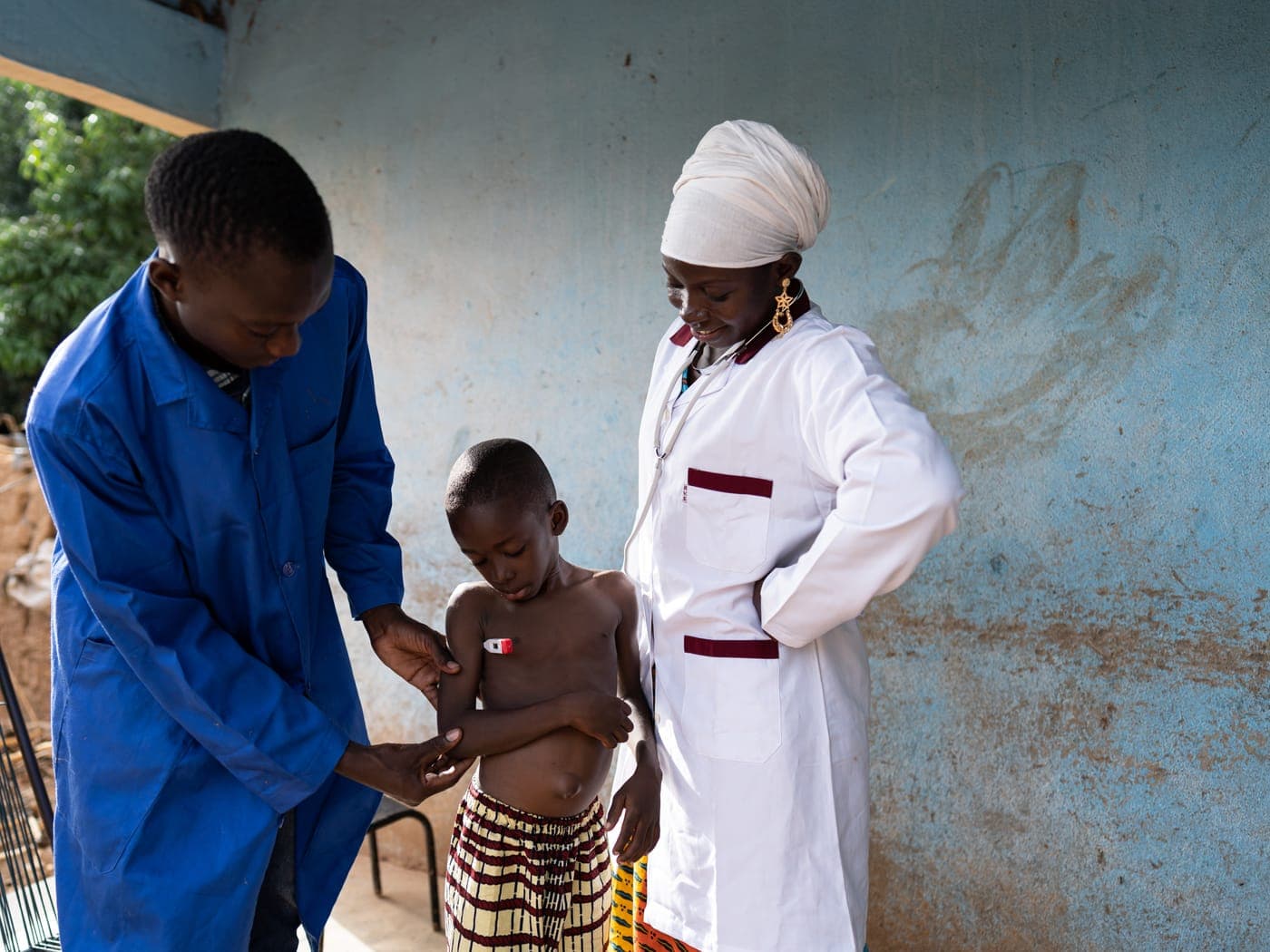 A health worker checking a young child at a rural clinic.