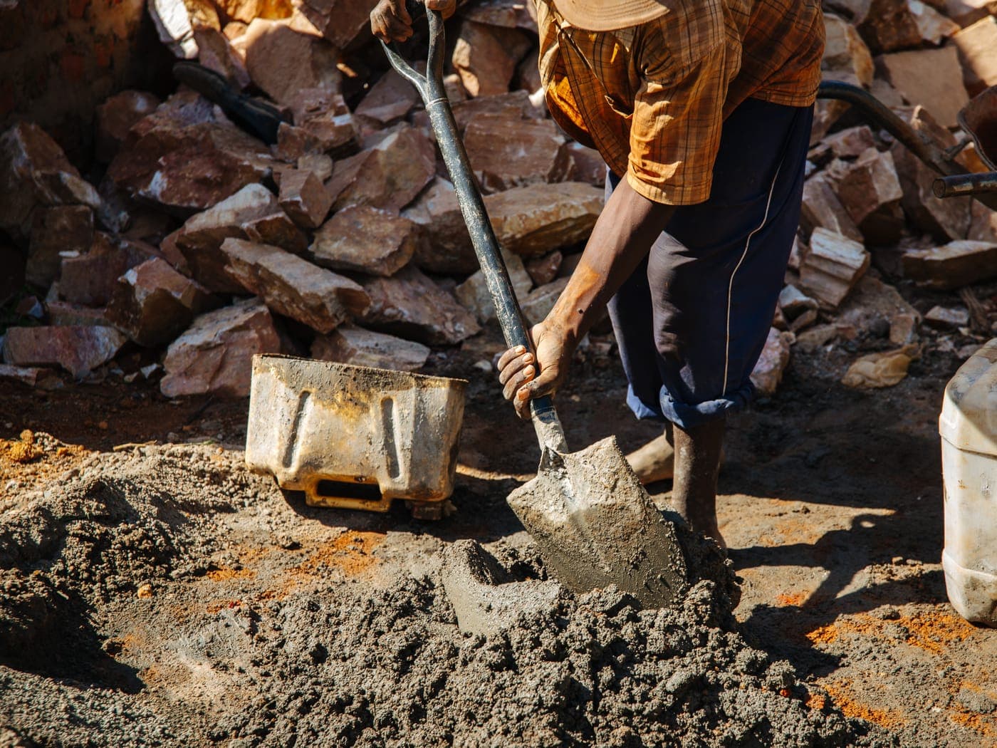 Local masons laying compressed-earth blocks for a community build.