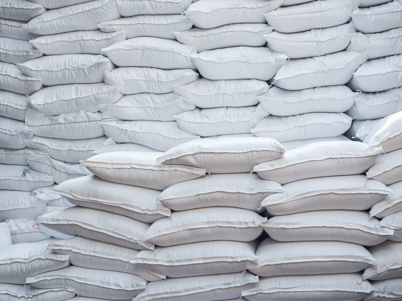 Sacks of grain stored in a clean, ventilated community warehouse.
